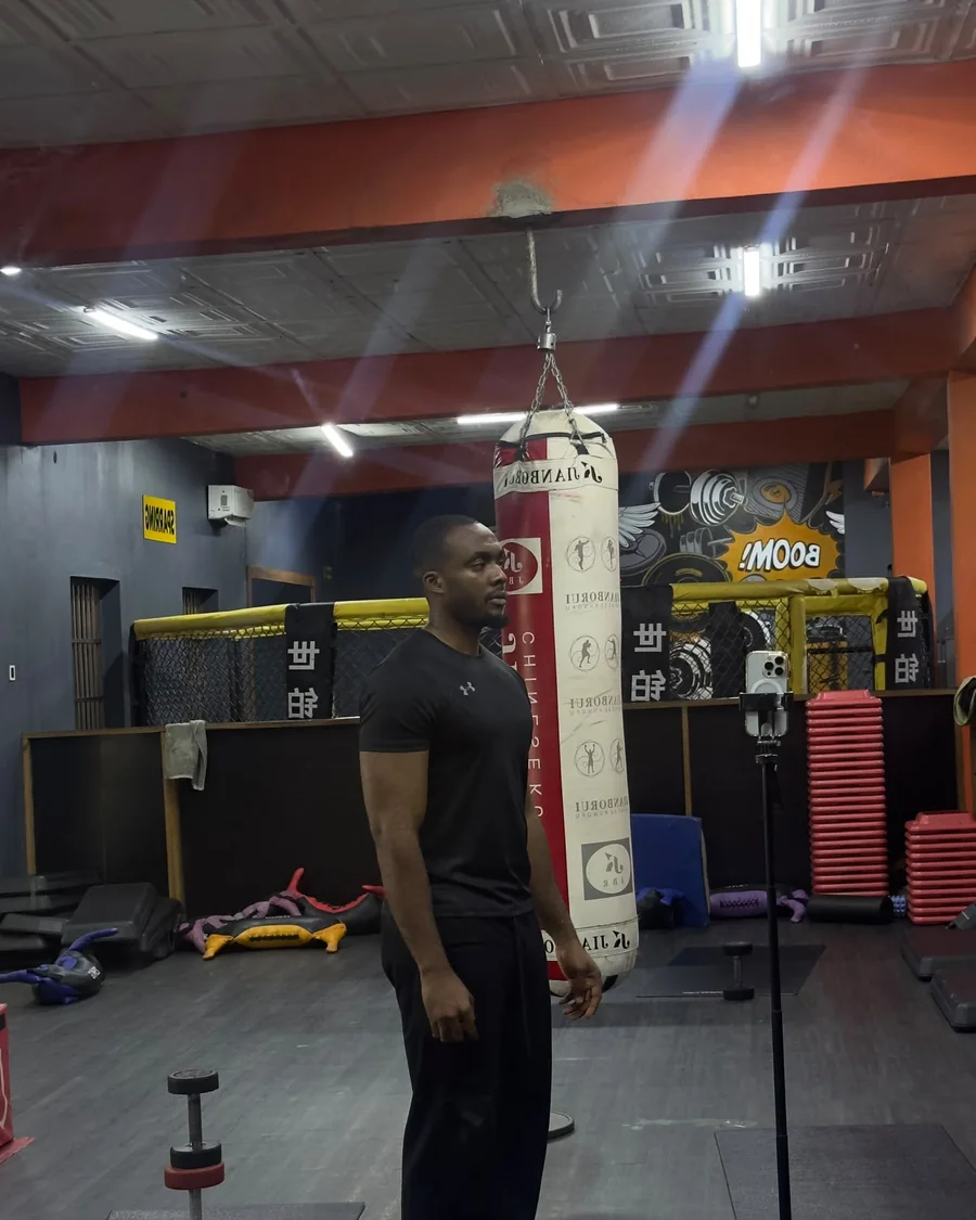 Emmanuel in a boxing gym beside a heavy bag